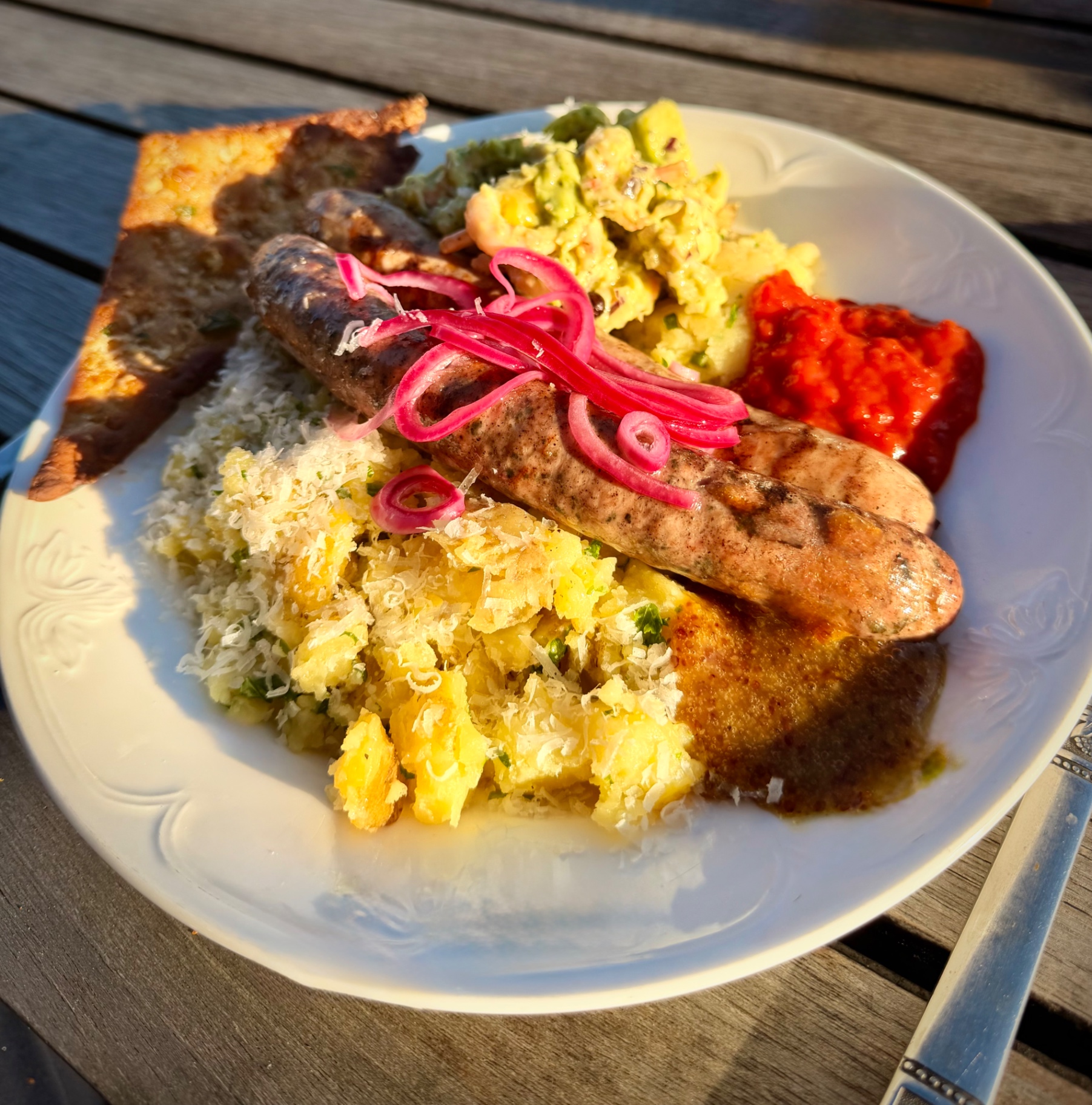 Tallrik med grillade hantverkskorvar och moderna tillbehör